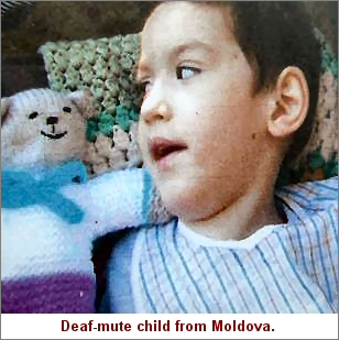 Photograph: Deaf-mute child from Moldova with her knitted teddy.